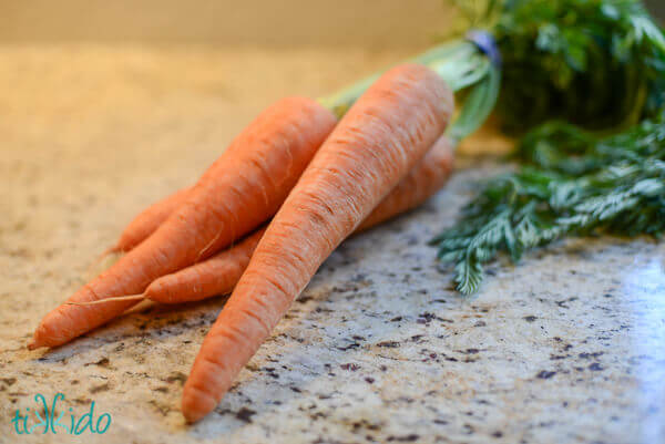 Carrots for the best Carrot Cake Recipe on a granite counter.