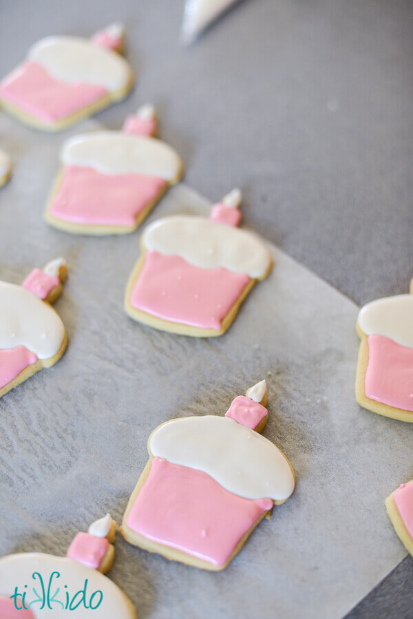 Cupcake shaped sugar cookies iced with a base layer of icing.