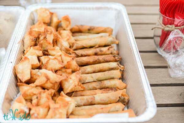 Crab Rangoon and lumpia in a catering tray.