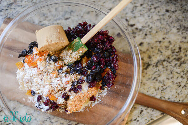 Soft granola bars ingredients in a clear bowl on a granite countertop.