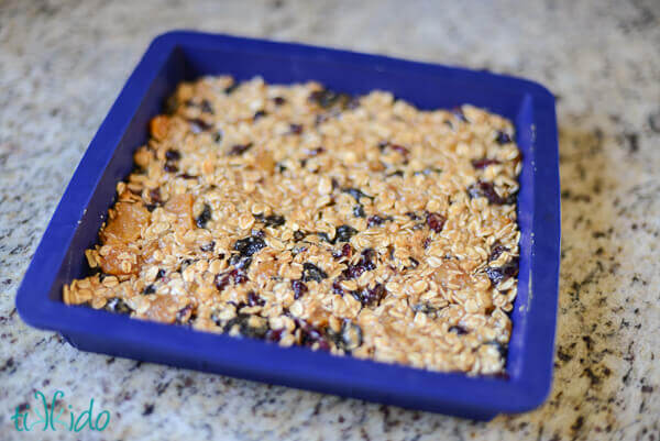 Unbaked homemade soft granola bars pressed into a silicone baking pan before cooking in the oven.