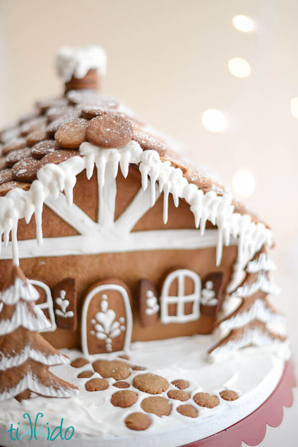Gingerbread house decorated with royal icing, with a gingerbread cobblestone path.