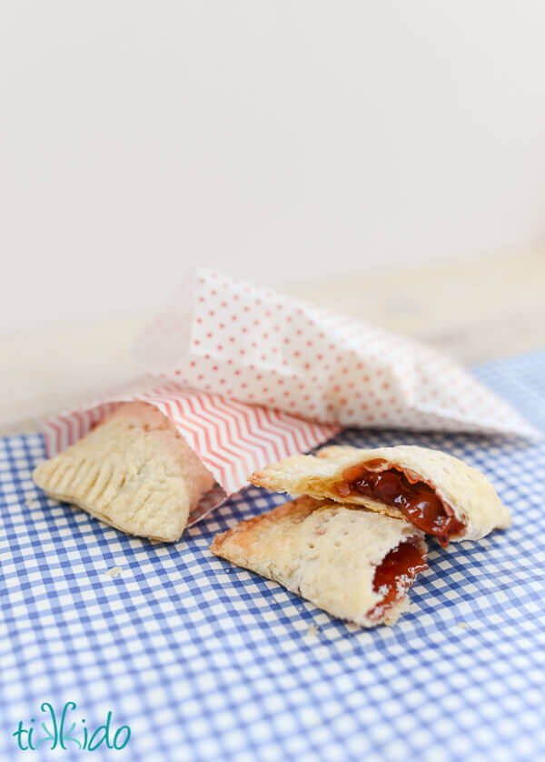 Cherry hand pies on a blue gingham surface.