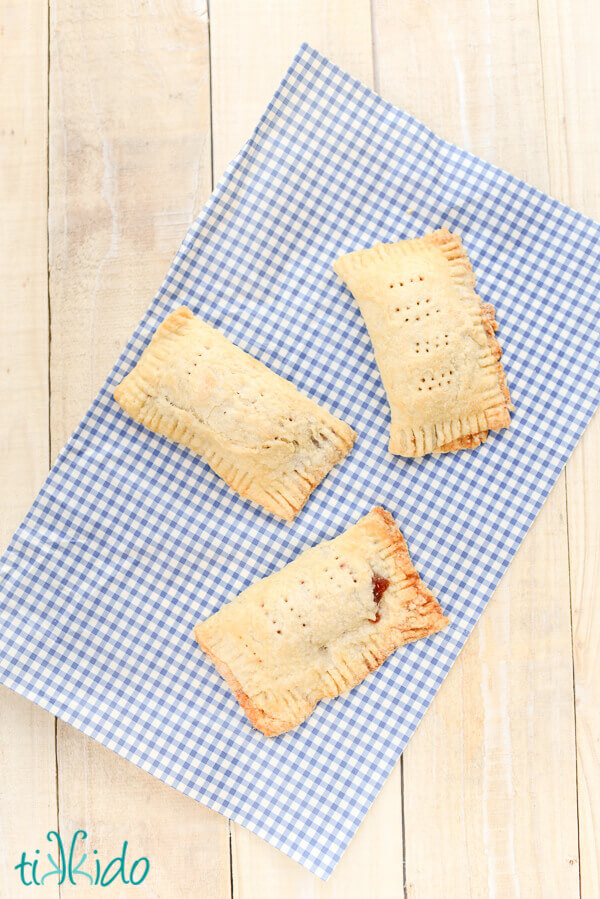 Cherry and Raspberry hand pies on a blue gingham napkin.