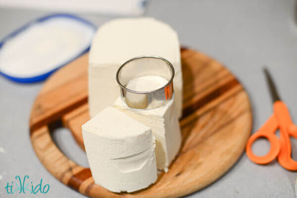 Vanilla ice cream being cut into shape for ice cream sandwiches.