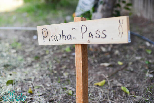 Handmade wooden sign reading Piranha Pass at the Jungle Party