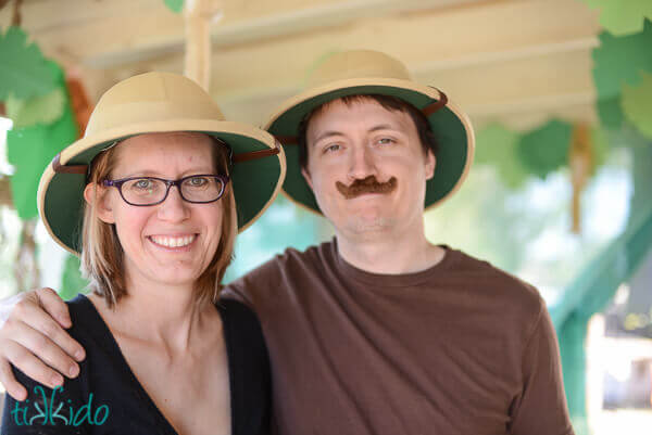 Mom and dad wearing pith helmets and a false mustache at the Jungle Party
