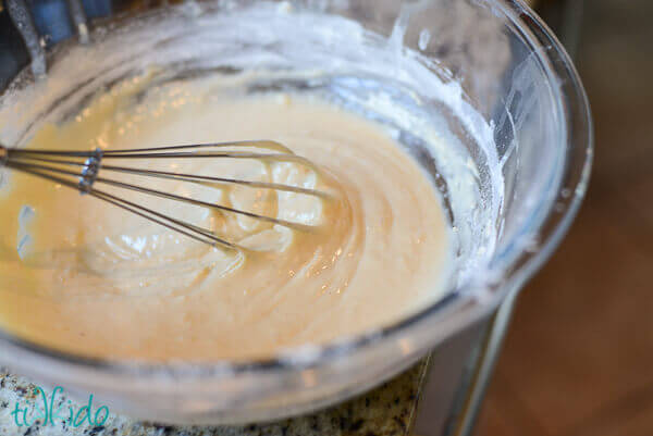 Homemade funnel batter being mixed in a clear bowl.