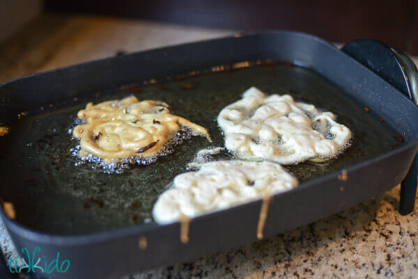 Homemade funnel batter frying in hot oil.