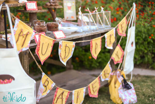 Party bunting for the Mud Pie Bakery party made out of fabric and twigs.