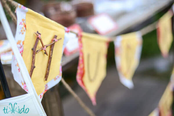 Letters on fabric bunting made out of twigs.