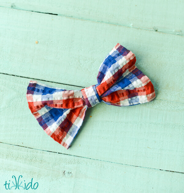 Hair Bow made with a no sew fabric bow in red, white, and blue plaid fabric.