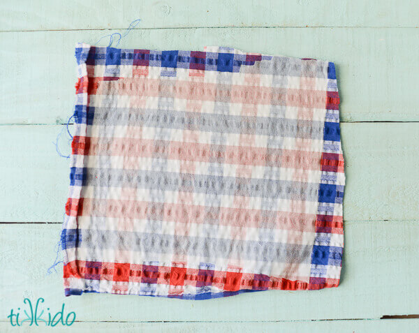 Rectangle of red, white, and blue seersucker plaid fabric for a no sew hair bow.