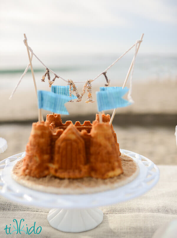 Nautical monogram cake topper on a sandcastle shaped cake.