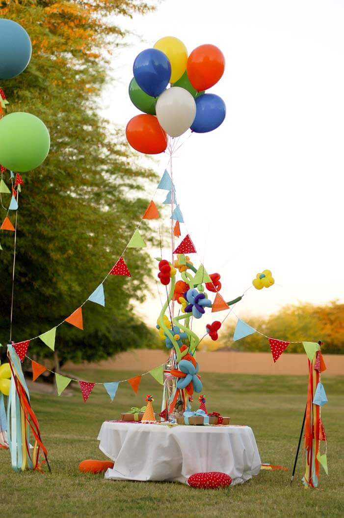 Balloon decorations over a table at a Balloon Birthday Party in a park.