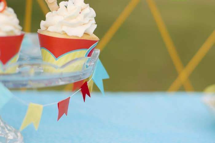 Miniature ribbon bunting decorating a cake stand holding cupcakes.