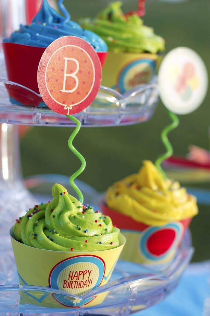 Cupcakes at the Balloon Birthday Party with cupcake toppers made from a twisty birthday candle and printable balloon cupcake toppers.