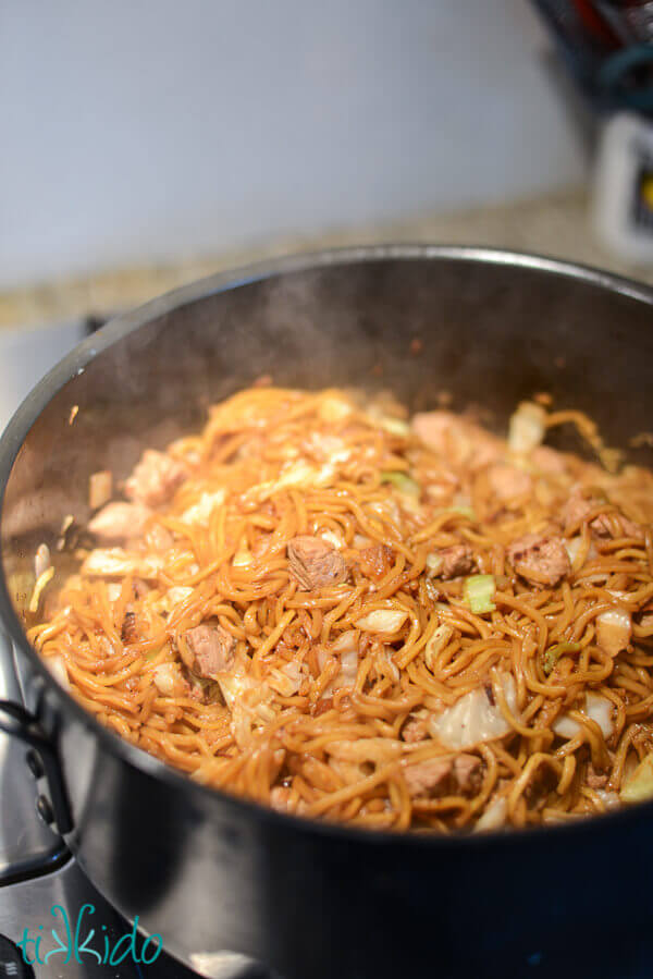 Pancit canton being cooked in a large pot on the stove.