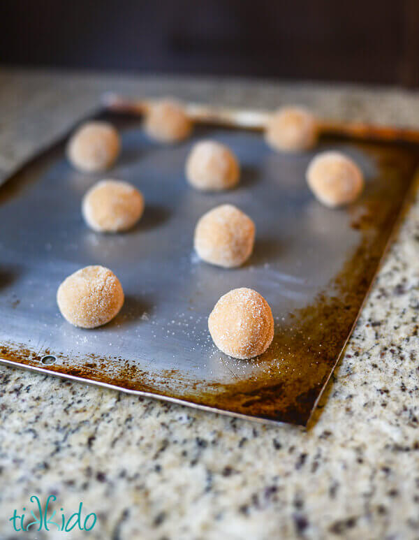 Balls of peanut butter cookie dough on a baking sheet.