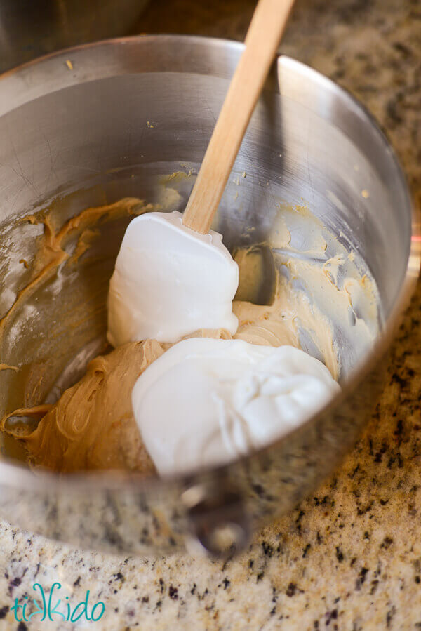 No bake peanut butter pie filling being folded together with a spatula.