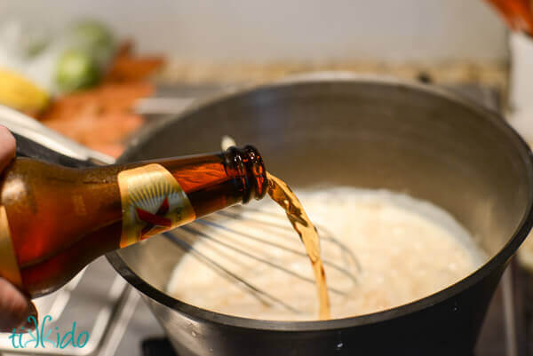 Beer pouring into a pot with roux