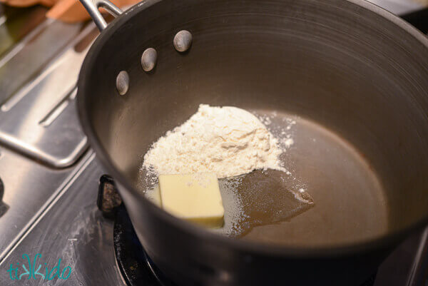 Saucepan with flour and a pat of butter just beginning to melt.