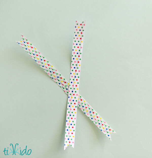 Two DIY twist ties made with polka dot washi tape on a light blue background.