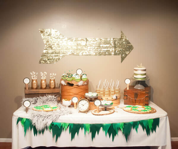 Peter Pan party dessert table with green felt peter pan inspired bunting on the front of the table.