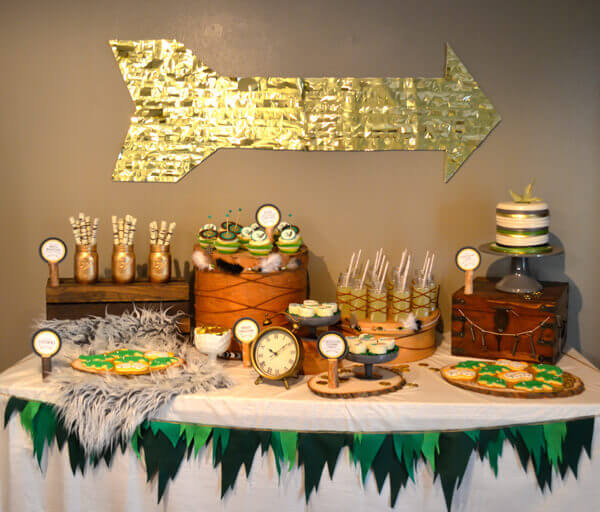 Peter Pan party dessert table with green felt peter pan inspired bunting on the front of the table.