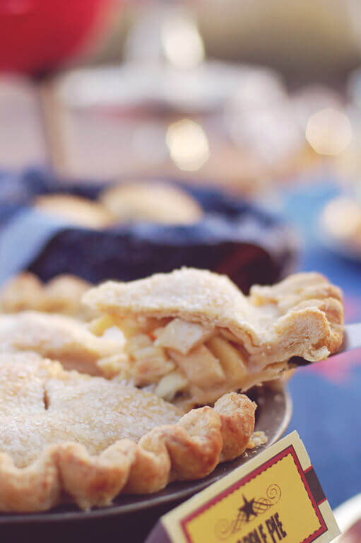 Slice of homemade apple pie being lifted out of the pie tin.