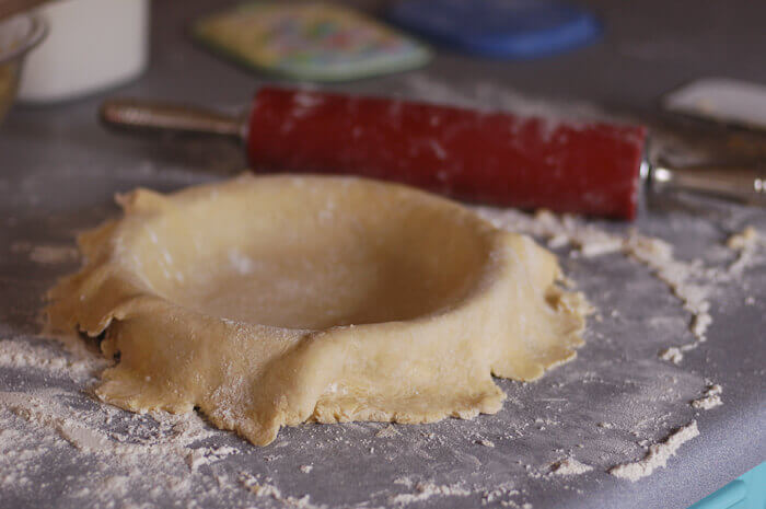 Pie crust draped over a pie tin for homemade apple pie.