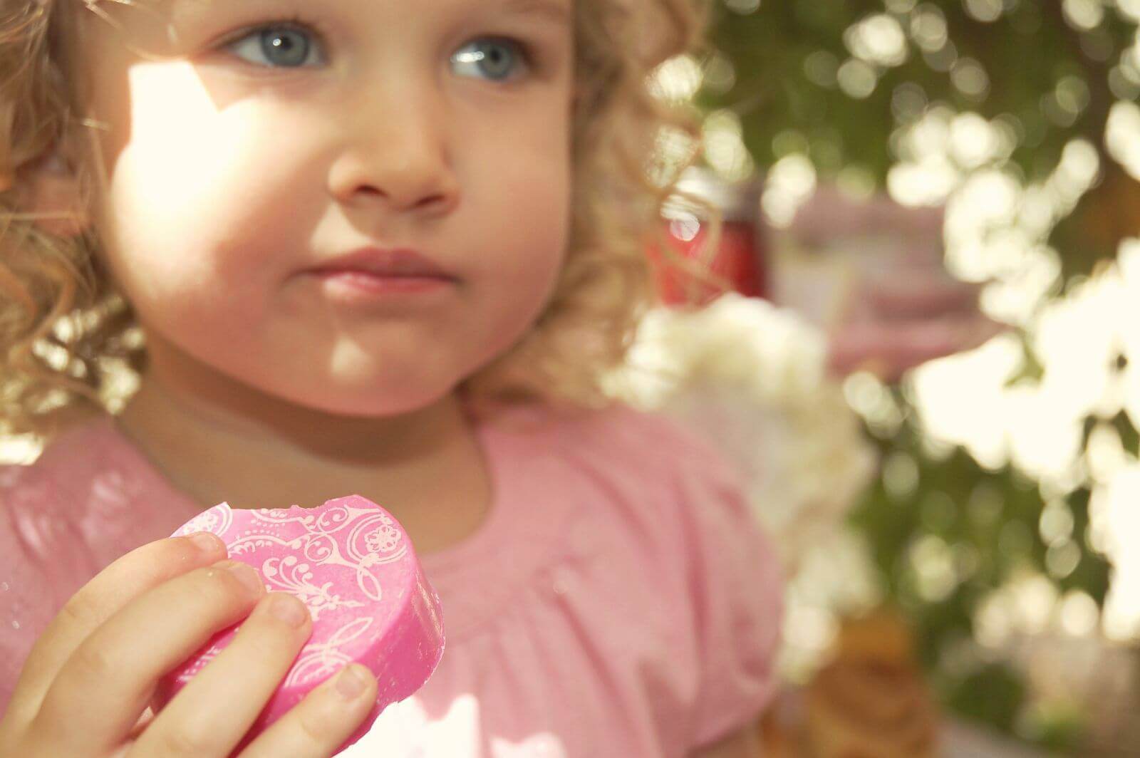 Little girl eating a pink Fancy Chocolate Covered Oreo