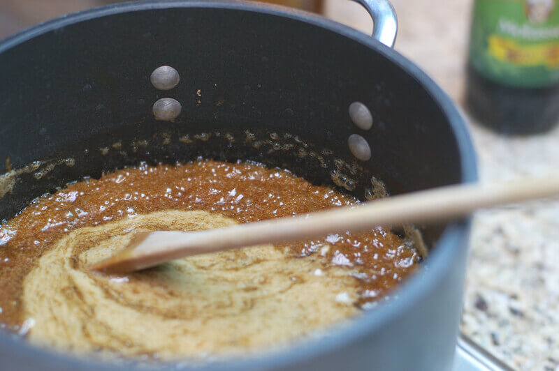 Caramel for caramel corn being cooked in a saucepan on the stove.