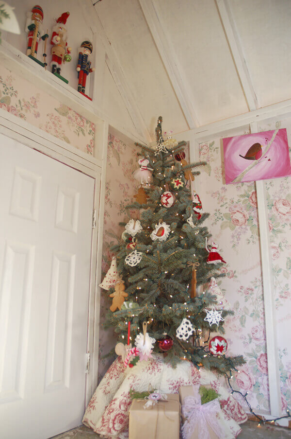 Quilted Christmas tree skirt on a live Christmas tree in a shabby chic playhouse.
