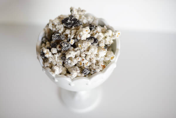 Cookies and Cream popcorn mix in a white container on a white background.