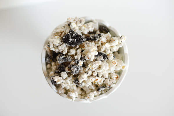 Cookies and Cream popcorn mix in a white container on a white background.