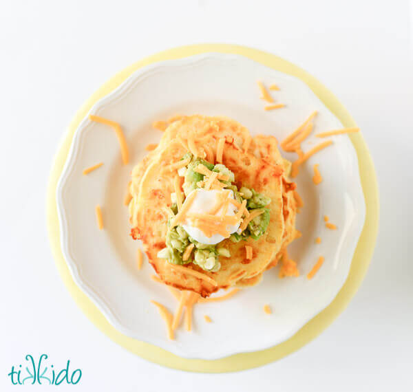 Savory cornmeal pancakes topped with sour cream, cheddar cheese, and sweet corn guacamole.