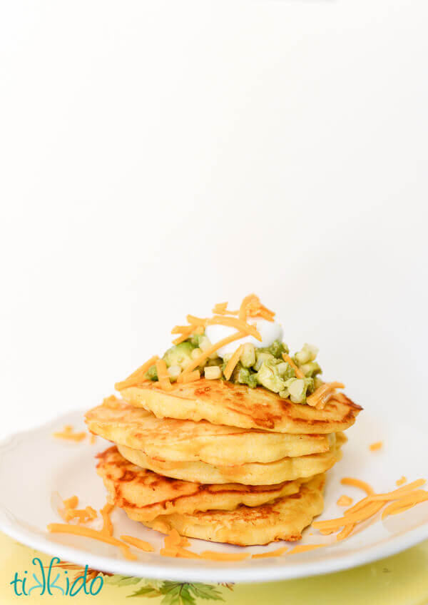 Savory cornmeal pancakes topped with sour cream, cheddar cheese, and sweet corn guacamole.