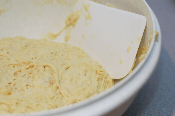 No Knead cinnamon roll dough in a large tupperware bowl