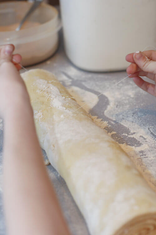 Cutting cinnamon roll dough using a thread.