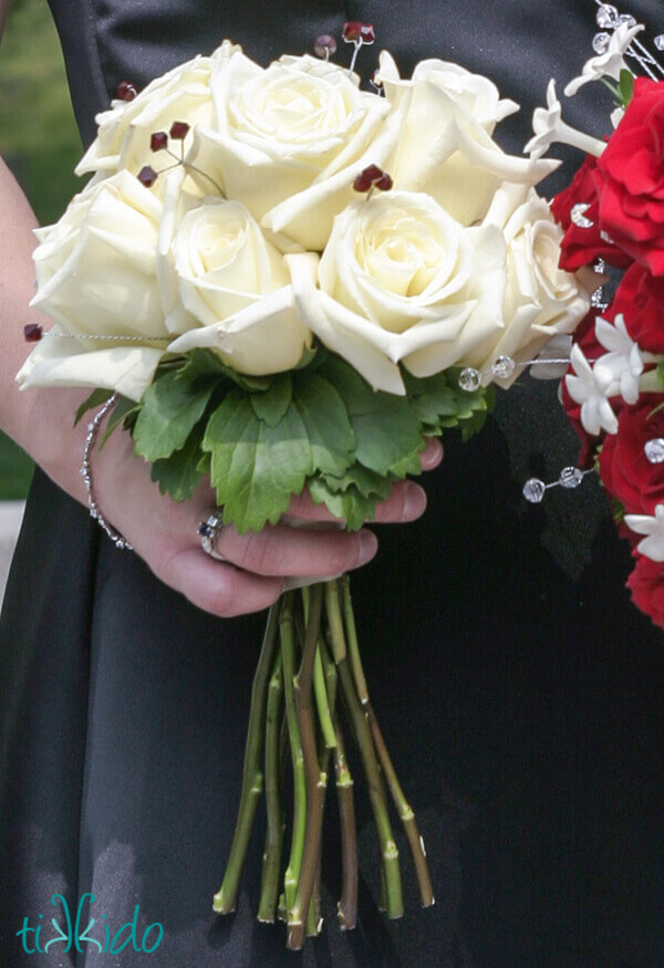 Bouquet of white roses with red crystal stems mixed in with the flowers.