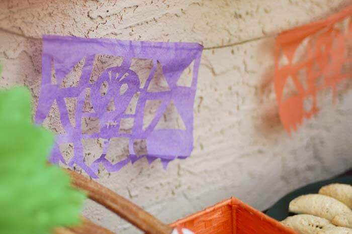 Papel Picado against a stucco wall.