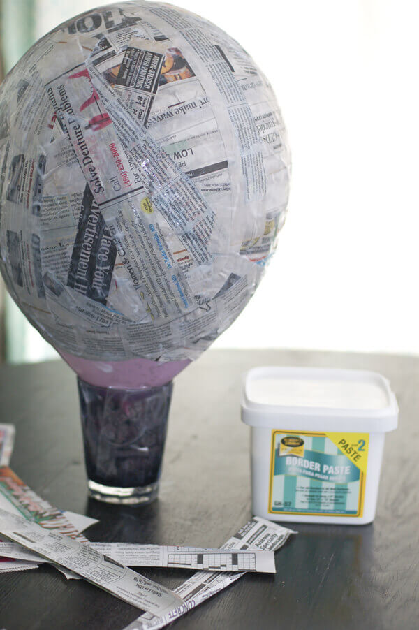 Balloon covered in strips of newspaper to make a piñata.