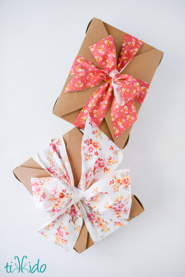 Two brown kraft boxes tied with homemade fabric ribbon bows