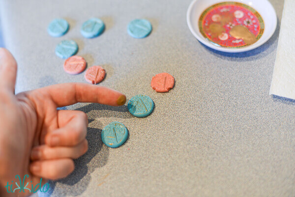 Faux wax seals being dry brushed with gold paint on the raised embossed monogram.