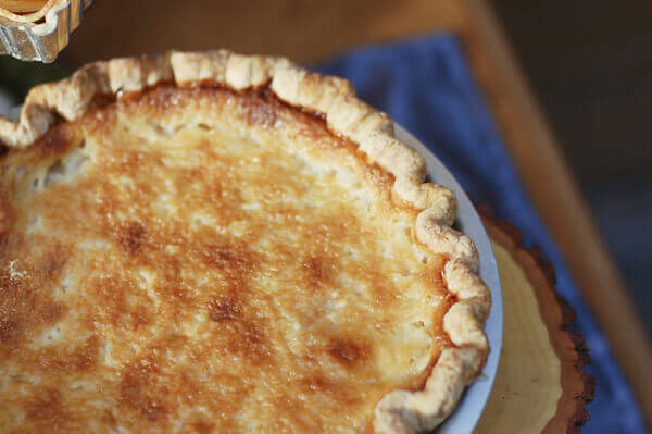 Hand pie, an old fashioned, eggless vanilla custard pie, in a pie dish on a Thanksgiving table.