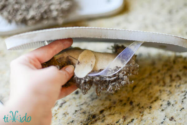 Photo showing felt straps being glued into place to secure the fur topper to the DIY hobbit feet..