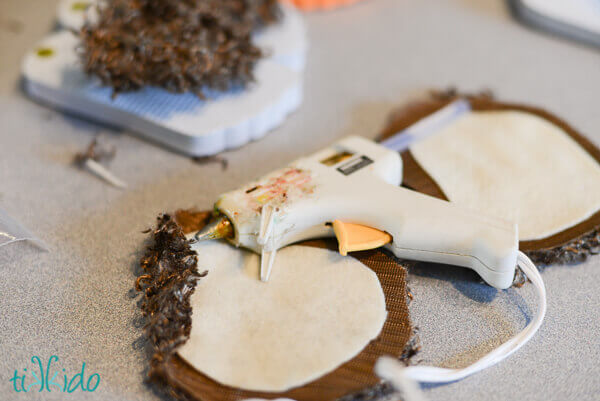 Faux fur being glued into place to make hobbit feet flip flops.