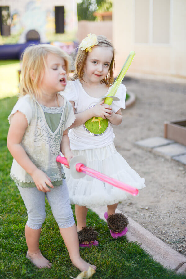 Two little girls at a LOTR birthday party, one wearing hairy hobbit feet flip flops.