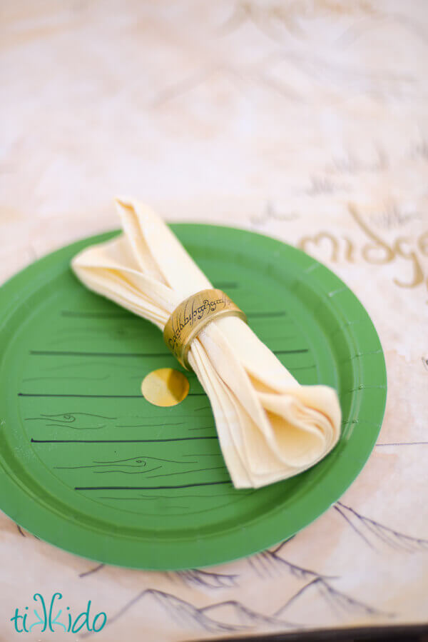 Lord of the Rings One Ring napkin rings for a hobbit party on a green paper plate that looks like a hobbit hole door.